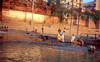 Mrs-H > Here's the gross you out portion of the slide show. This is a burning ghat. Usually you'll see two or three bodies burning here at any one time. I'll explain the scene for you.

Kids on the left are taking leftover firewood that was used to burn somebody's relative the night before. Girl on the right is getting some drinking water from the river. Guy in the water with the basket is sifting for jewelry that may have been attached to the cremated bodies. 

Just another day in Varanasi.