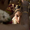 The groom is tying the Mangalsutra around the bride's neck. This necklace is the equivalent to a wedding ring.

Traditionally, a married woman never removed her mangalasutra. If she became a widow, it was cut off.